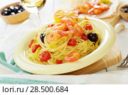 Seafood spaghetti pasta dish with shrimps and cherry tomatoes served with white wine. Стоковое фото, агентство Ingram Publishing / Фотобанк Лори