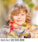 Happy child in autumn park against yellow blurred leaves background. Стоковое фото, фотограф Igor Yaruta / Ingram Publishing / Фотобанк Лори