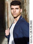 Good looking young man with blue eyes in the street. Model of fashion in urban background wearing white t-shir and blue jacket. Стоковое фото, фотограф Javier Sánchez Mingorance / Ingram Publishing / Фотобанк Лори