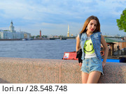 Портрет молодой девушки на набережной реки Нева на фоне Кунсткамеры, Ростральной колонны и Петропавловской крепости в Санкт-Петербурге (2018 год). Редакционное фото, фотограф Максим Мицун / Фотобанк Лори