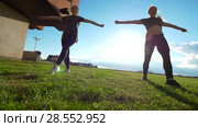 Two female gymnast workout simultaneously at summer sunset. Стоковое видео, видеограф Константин Шишкин / Фотобанк Лори