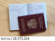 Открытая трудовая книжка с записью "Уволен по собственному желанию" и паспорт Российской федерации. Стоковое фото, фотограф Евгений Бусурманов / Фотобанк Лори