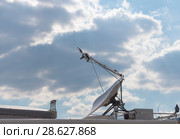 Satellite antenna on the wall with blue sky. Стоковое фото, фотограф Фотограф / Фотобанк Лори