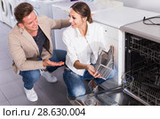 Couple looking at dishwashers in domestic appliances shop. Стоковое фото, фотограф Яков Филимонов / Фотобанк Лори