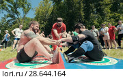 KAZAN, RUSSIA - JUNE 23, 2018: Traditional Tatar festival Sabantuy - Strong muscular men in battle of pulling the stick outdoors. Редакционное видео, видеограф Константин Шишкин / Фотобанк Лори