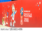 Чемпионат мира по футболу FIFA 2018 года в России. Баннер с эмблемой Кубка Мира и талисманом волченком Забивакой на ограждении фан-зоны на Красной площади. Москва. Редакционное фото, фотограф Алёшина Оксана / Фотобанк Лори