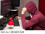 Интернет тролль у компьютера. Неприятный мужчина в капюшоне общается в сети. Стоковое фото, фотограф Лариса Капусткина / Фотобанк Лори