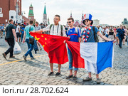Чемпионат мира по футболу FIFA 2018 в России. Французские и китайские болельщики с национальными флагами на Красной площади. Москва. Редакционное фото, фотограф Алёшина Оксана / Фотобанк Лори