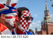 Болельщики национальных сборных Англии и Хорватии по футболу с разрисованными лицами в цвета национального флага на Красной площади во время Чемпионата мира по футболу FIFA 2018 в городе Москве, Россия. Редакционное фото, фотограф Николай Винокуров / Фотобанк Лори