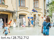Дети играют в фонтане в жаркую погоду на Биржевой площади. Москва (2018 год). Редакционное фото, фотограф Алёшина Оксана / Фотобанк Лори