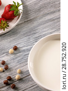 Ripe strawberries, cereal balls and a plate of milk on a gray wooden table. Top view. Стоковое фото, фотограф Ярослав Данильченко / Фотобанк Лори