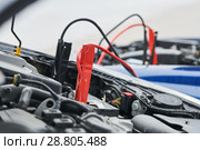 Automobile help. booster jumper cables charging automobile discharged battery. Стоковое фото, фотограф Дмитрий Калиновский / Фотобанк Лори