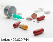 Needle syringe and pills on white background. The focus of the tip of the needle. Стоковое фото, фотограф Элина Гаревская / Фотобанк Лори
