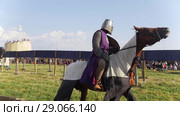 Festival of the middle ages. Men in a knightly armor on horseback take part in the tournament. The audience watching. Стоковое видео, видеограф Константин Шишкин / Фотобанк Лори