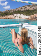 Woman relaxing on a summer sailing cruise,lying in hammock of luxury catamaran near picture perfect white sandy beach on Spargi island in Maddalena Archipelago, Sardinia, Italy. Стоковое фото, фотограф Matej Kastelic / Фотобанк Лори