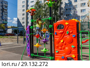Ребенок залезает на стенку для лазания на современной красивой детской площадке. (2018 год). Стоковое фото, фотограф Светлана Голинкевич / Фотобанк Лори