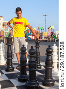 Игра в уличные шахматы, подросток в раздумье. Стоковое фото, фотограф Кекяляйнен Андрей / Фотобанк Лори
