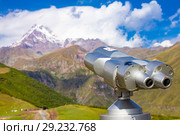 Binoscope directed towards the snowy mountain tops of Kazbeg from the view point Gergeti Trinity Church Tsminda Sameba Holy Church near the village of Gergeti in Georgia (2018 год). Редакционное фото, фотограф Алексей Ширманов / Фотобанк Лори