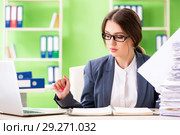 Young female employee very busy with ongoing paperwork. Стоковое фото, фотограф Elnur / Фотобанк Лори