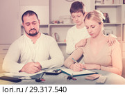 Tense parents with sad son writing documents. Стоковое фото, фотограф Яков Филимонов / Фотобанк Лори