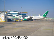 Самолет Boeing 777-200 (EZ-A778) авиакомпании Turkmenistan Airlines  у  телескопического трапа  международного терминала аэропорта. Ашхабад, Туркменистан (2017 год). Редакционное фото, фотограф Виктор Карасев / Фотобанк Лори