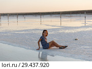happy girl enjoying the sunset, touches water of a salt lake sitting on crystals. Стоковое фото, фотограф Ирина Мойсеева / Фотобанк Лори