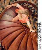 girl in silk robe stand on wooden spiral staircase. Стоковое фото, фотограф katalinks / Фотобанк Лори
