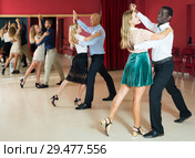 Positive adult couples dancing tango together in modern studio. Стоковое фото, фотограф Яков Филимонов / Фотобанк Лори