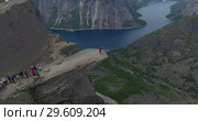 Утес Trolltunga (Язык Тролля). Очередь на край скалы для фотографирования, человек подходит к краю. Норвегия (2018 год). Редакционное видео, видеограф Кекяляйнен Андрей / Фотобанк Лори