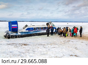 Embarkation people on the passenger Neptune hovercraft at the ice (2018 год). Редакционное фото, фотограф FotograFF / Фотобанк Лори