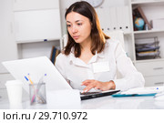 Upset woman working with laptop and papers at the office. Стоковое фото, фотограф Яков Филимонов / Фотобанк Лори