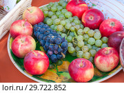 Autumn harvest: fruit on a plate, red apples, green and black grapes. Стоковое фото, фотограф Катерина Белякина / Фотобанк Лори