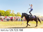Russia, Samara, July, 2018: a Cossack girl rides a horse and performs tricks. Редакционное фото, фотограф Акиньшин Владимир / Фотобанк Лори