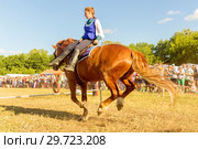 Russia, Samara, July, 2018: a Cossack girl rides a horse and performs tricks. Редакционное фото, фотограф Акиньшин Владимир / Фотобанк Лори