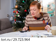 Mature woman calculates utility costs in the new year. Стоковое фото, фотограф Яков Филимонов / Фотобанк Лори