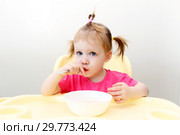 Lovely little girl eating soup at home kitchen. Стоковое фото, фотограф ivolodina / Фотобанк Лори
