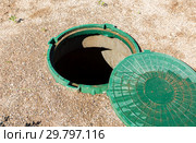 Opened unsecured sewer manhole of rural septic tank with green plastic cover. Стоковое фото, фотограф FotograFF / Фотобанк Лори