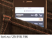 Сайт Amazon.com на экране мобильного телефона. Смартфон лежит в заднем кармане джинсовых штанов (2019 год). Редакционное фото, фотограф E. O. / Фотобанк Лори