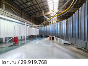Powder coating line. Metal panels are suspended on an overhead conveyor line. Стоковое фото, фотограф Андрей Радченко / Фотобанк Лори