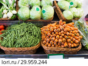 Green beans and carrots in wicker baskets on counter of vegetable store. Стоковое фото, фотограф Татьяна Яцевич / Фотобанк Лори