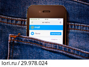 Cайт Mail.Ru на экране телефона. Смартфон в заднем кармане джинсовых штанов (2019 год). Редакционное фото, фотограф E. O. / Фотобанк Лори