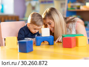 Curious baby and kindergartener playing developmental toys. Стоковое фото, фотограф Оксана Кузьмина / Фотобанк Лори