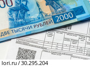 Коммунальный платежи за водоснабжение и водоотведение. Квитанция на оплату коммунальных услуг за воду и двухтысячные деньги. Стоковое фото, фотограф Игорь Низов / Фотобанк Лори