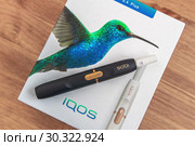 IQOS 2.4 Plus — инновационная система нагревания табака. Держатель со стиком на упаковочной коробке (2019 год). Редакционное фото, фотограф Владимир Сергеев / Фотобанк Лори