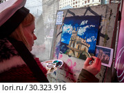 Девушка пишет пейзаж с изображением замка "Ласточкино гнездо" на площадке фестиваля "Крымская весна", приуроченного к 5-летию воссоединения Крыма с Россией, на Манежной площади города Москвы, Россия (2019 год). Редакционное фото, фотограф Николай Винокуров / Фотобанк Лори