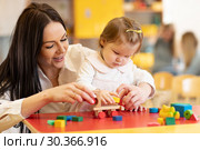 Kid with mother play with colorful wooden block toys on table. Стоковое фото, фотограф Оксана Кузьмина / Фотобанк Лори