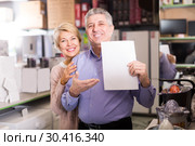 Mature couple buying on credit agreement for home appliances. Стоковое фото, фотограф Яков Филимонов / Фотобанк Лори