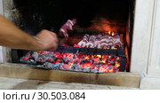 Georgian man cooks shish kebab on skewers in a fireplace stove. Стоковое видео, видеограф Сергей Пристяжнюк (Serg Zastavkin) / Фотобанк Лори