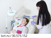 Врач-косметолог проводит пациентке аппаратную процедуру для улучшения роста волос. Дарсонваль. Стоковое фото, фотограф Наталья Гармашева / Фотобанк Лори