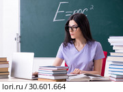 Young female teacher student in front of green board. Стоковое фото, фотограф Elnur / Фотобанк Лори